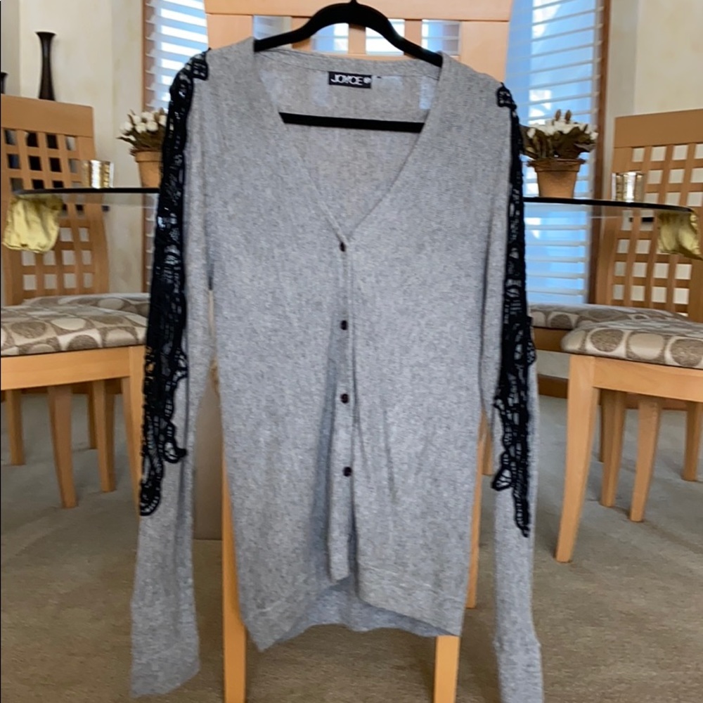 Gray v neck button down sweater with black crochet embellishments on arm…